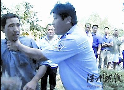 一村民欲阻止拆遷，被一個(gè)身穿監(jiān)察大隊(duì)制服的工作人員掐住脖子，野蠻推開