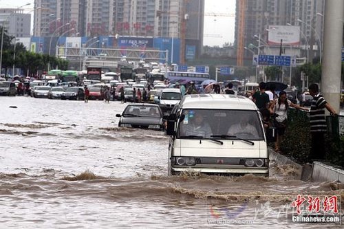 6月18日，車輛在武漢積水的道路上艱難行駛。當(dāng)日，武漢降大到暴雨，全城多處交通要道積水嚴(yán)重，交通幾近癱瘓。中新社發(fā) 張暢 攝