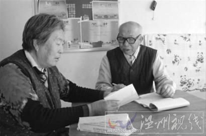 昨日中午11時許，李明生和老伴正在整理著還錢的收條。記者 蔡紅鑫 攝。