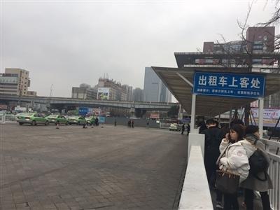 火車北站出租車上客處，一邊是排起長隊的乘客，一邊是寥寥可數(shù)的出租車。